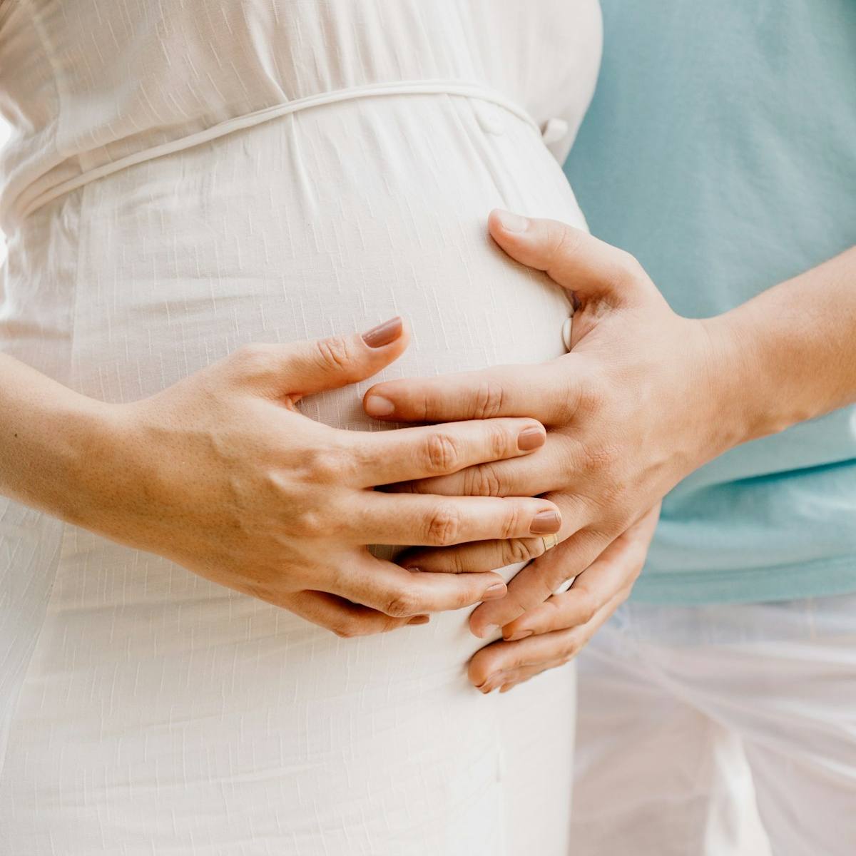 Sage-femme palpant le ventre d'une patiente lors d'une consultation de suivi.
