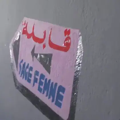 Plaque du cabinet apposée sur la façade, avec les mentions bilingues « قابلة » et « SAGE FEMME ».